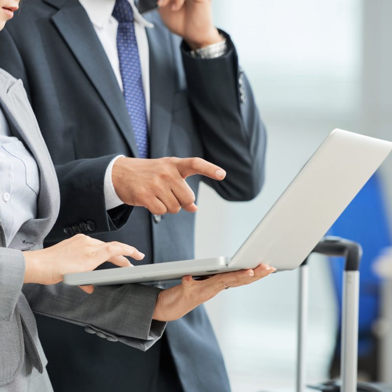unrecognizable-man-woman-business-suits-looking-laptop-screen-together